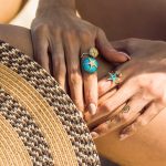 Woman wearing gold plated ring sea urchins with turquoise enamel