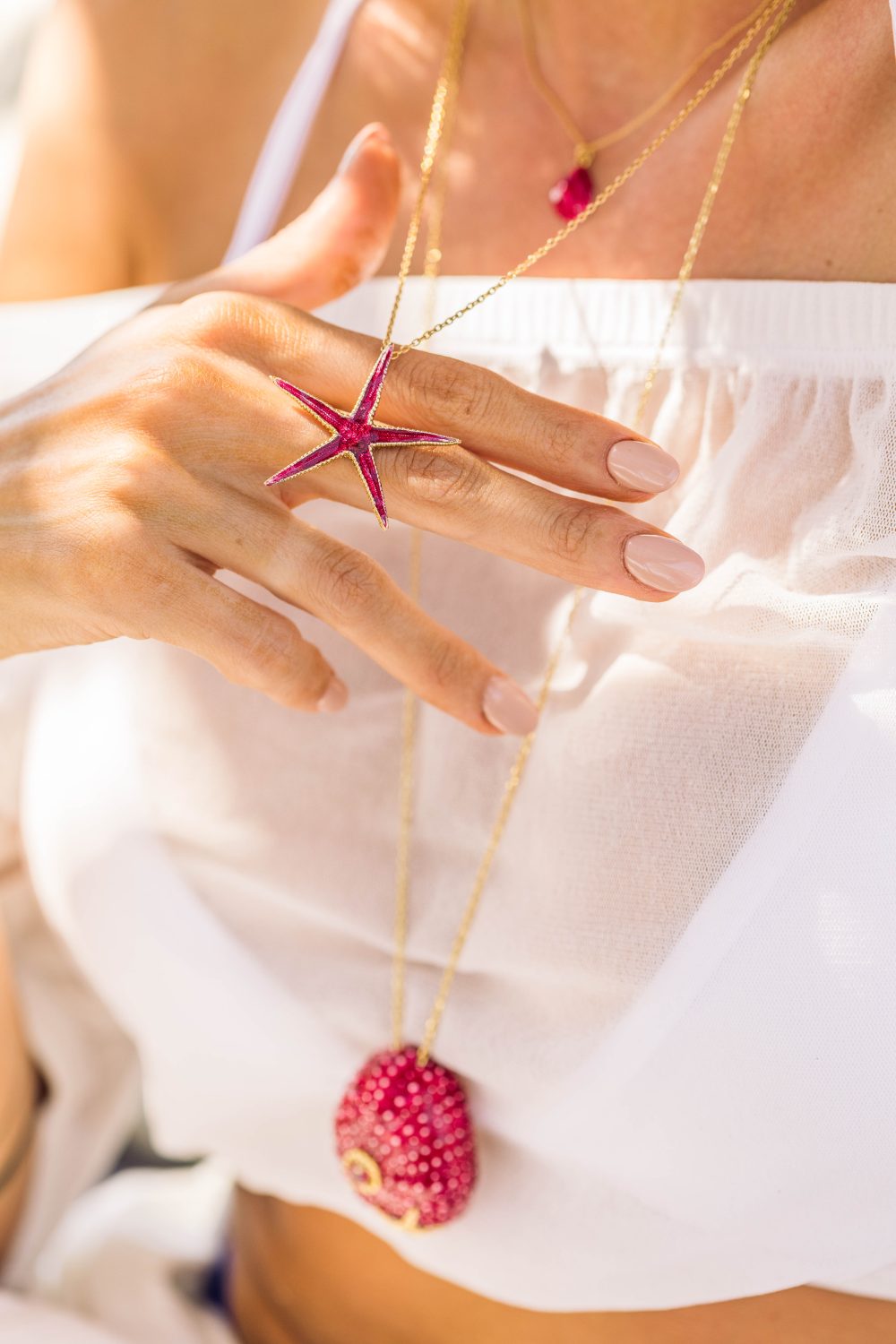 woman wears sterling silver gold plated starfish necklace with red enamel
