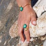Woman wearing gold plated ring sea urchins with green enamel