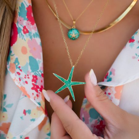 woman wears sterling silver gold plated starfish necklace with green enamel