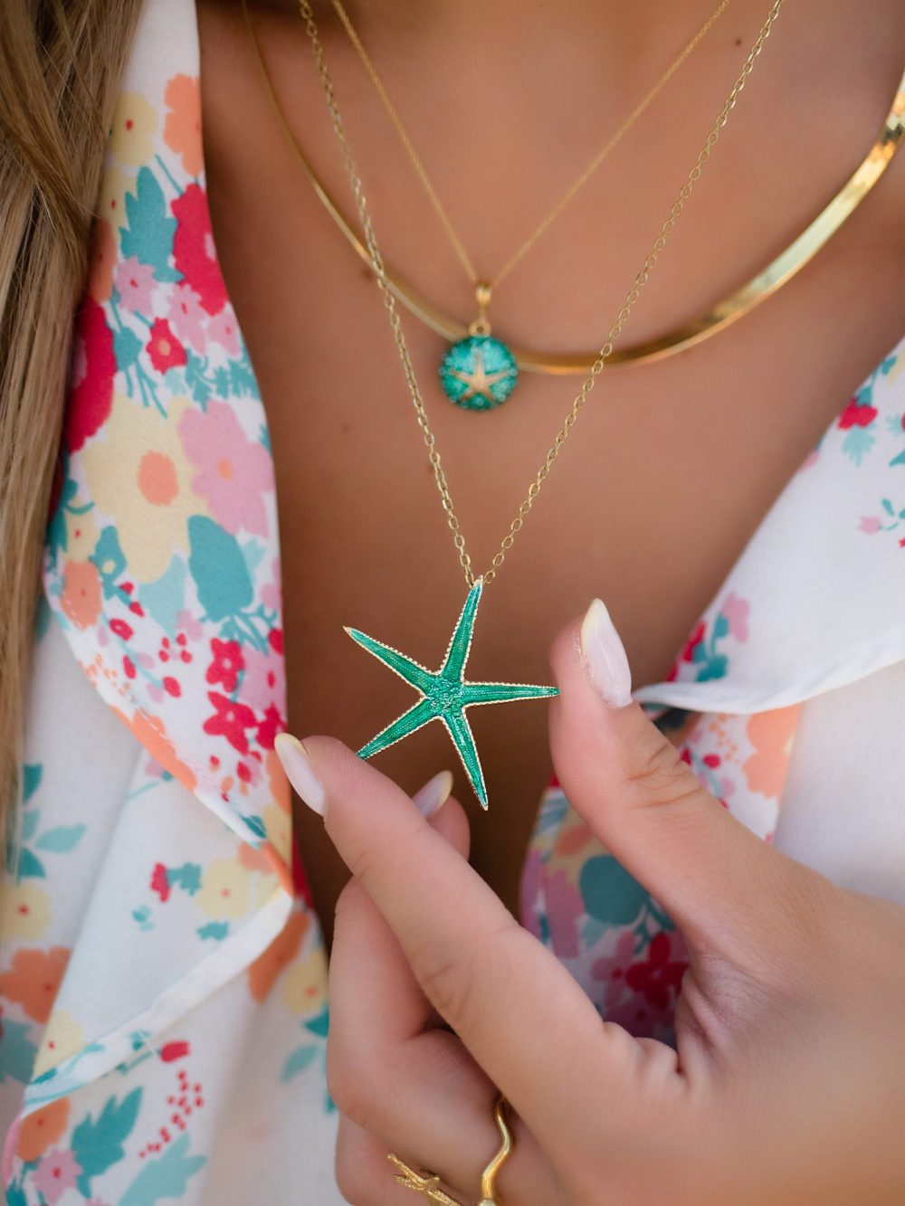 woman wears sterling silver gold plated starfish necklace with green enamel