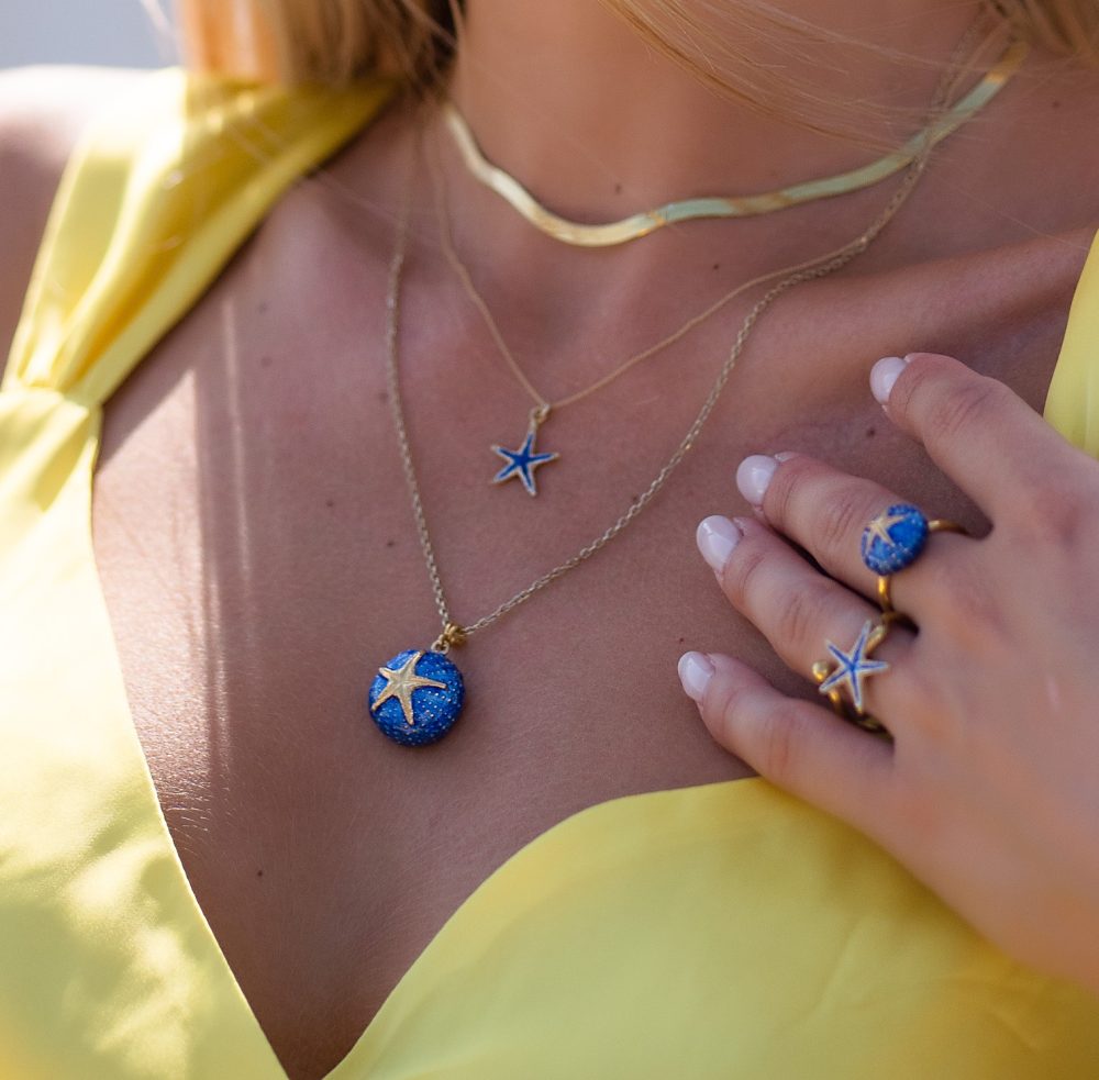 girl wearing sterling silver starfish necklace with blue enamel