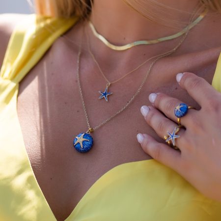 girl wearing sterling silver starfish necklace with blue enamel